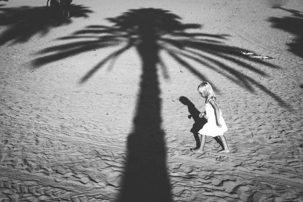 Foto en blanco y negro de niña con palmera